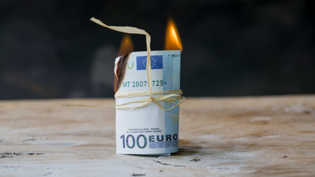 Symbolbild: Eine Rolle brennender 100€-Scheine